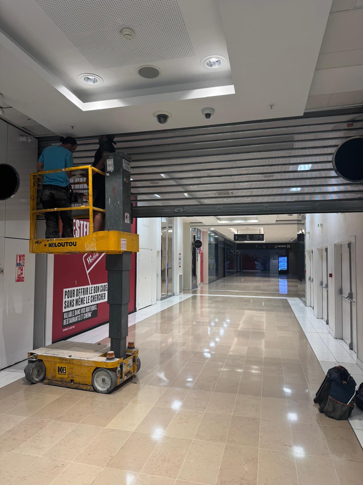 Après - Remplacement d'axe motorisé rideau métallique à lames micro-perforées au centre commercial La Part-Dieu à Lyon