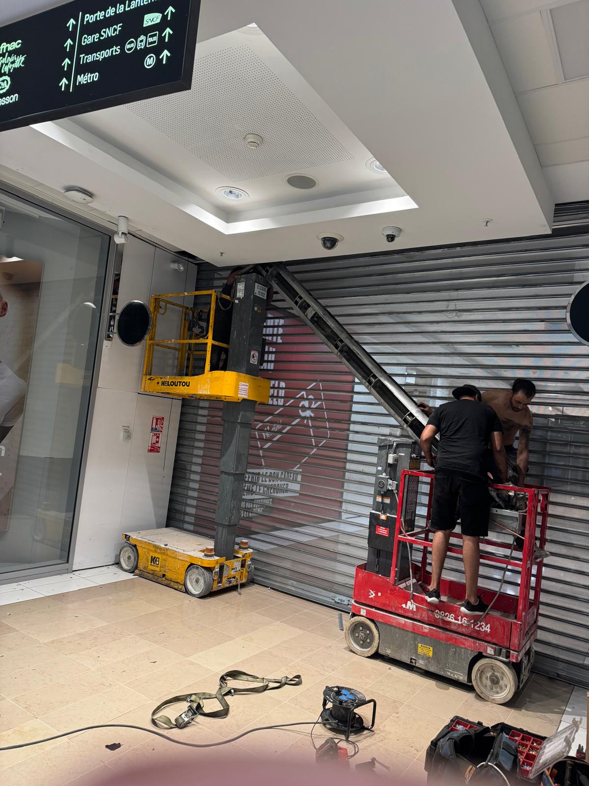 Avant - Remplacement d'axe motorisé rideau métallique à lames micro-perforées au centre commercial La Part-Dieu à Lyon